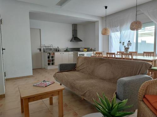 ein Wohnzimmer mit Sofa und Tisch in der Unterkunft Apartamento grande Bambú, Cala Montgó in L'Escala