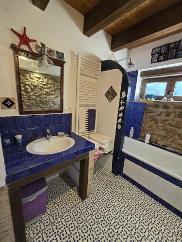 a bathroom with a blue sink and a bath tub at Casa Jerónimo in Loporzano