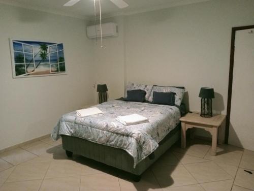 a bedroom with a bed with two lamps on it at Ocean Vista in Amanzimtoti