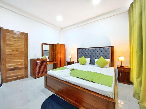 a bedroom with a large bed with green pillows at Catch Up Dambulla in Dambulla