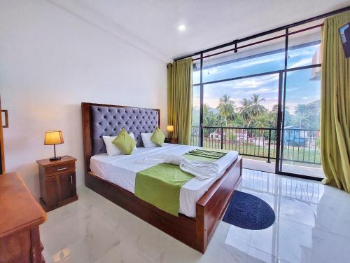 a bedroom with a bed and a large window at Catch Up Dambulla in Dambulla