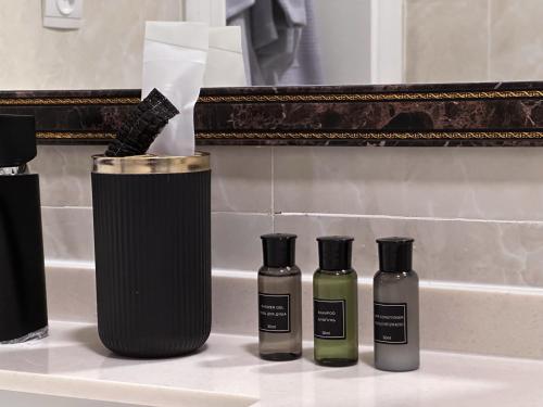 a group of three bottles on a bathroom counter at Stela Hotel in Shymkent