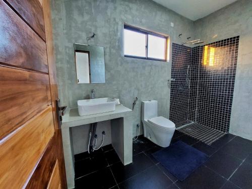 a bathroom with a sink and a toilet and a shower at Catch Up Dambulla in Dambulla