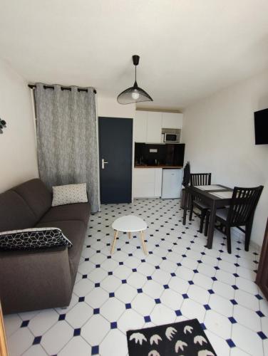 un salon avec un canapé et une table dans l'établissement Studio plain pied avec terrasse tout proche mer, à Courseulles-sur-Mer