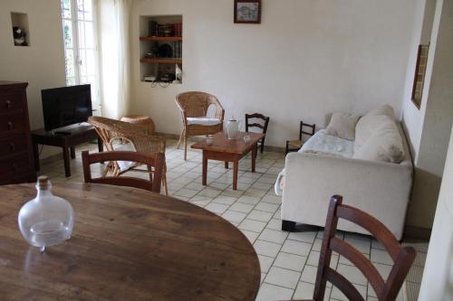 un salon avec une table, des chaises et un canapé dans l'établissement Maison de Village, à Entrechaux