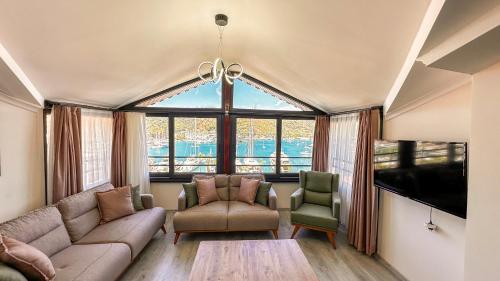 a living room with a couch and two chairs and a large window at Mykonut Boutique Suites in Fethiye