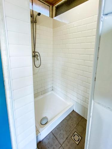 a bath tub in a bathroom with white tiles at Park Hotel Sóstó Faházak in Sóstófürdő