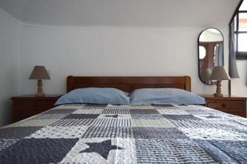 a bedroom with a bed with a quilt on it at Attic with a view-Σοφίτα με θέα in Platamonas