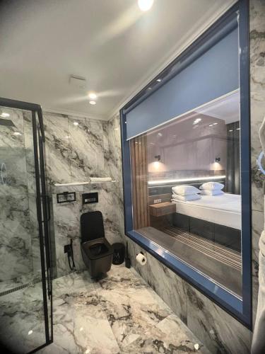 奇姆肯特的住宿－Sapar Standart Улучшенный полулюкс，带淋浴和卫生间的浴室以及1张床。
