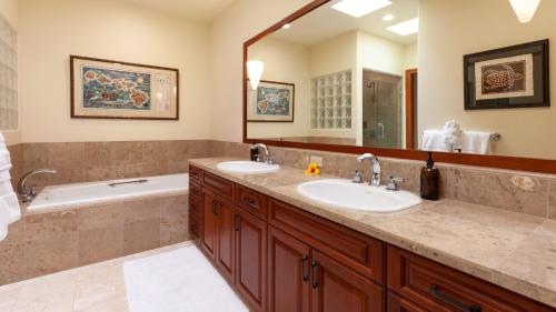 a bathroom with two sinks and a tub and a mirror at COCONUT TELEGRAPH Rejuvenating 3BR Villages Home Near Recreation Center in Waikoloa