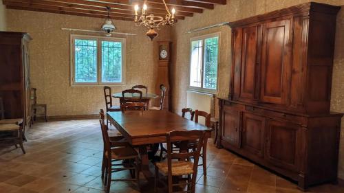 une salle à manger avec une table et des chaises en bois dans l'établissement Maison de vacances en campagne, à Cambounès