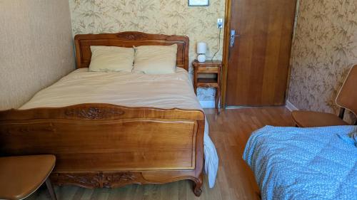 - une chambre avec un lit en bois et une tête de lit en bois dans l'établissement Maison de vacances en campagne, à Cambounès