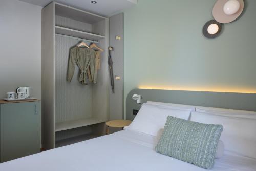 a bedroom with a white bed and a closet at Hotel Ilaria in Lucca
