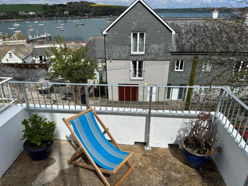 a blue chair sitting on a balcony with a house at Falmouth View in Falmouth