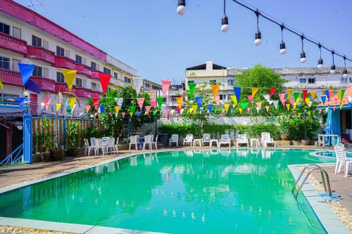 a swimming pool with chairs and tables and colorful flags at Marine paradise Encore in Pattaya South