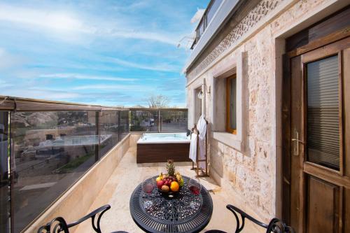 - un balcon avec une table et des fruits dans l'établissement Cappadocia Pegasos Cave Suite Hotel, à Uçhisar