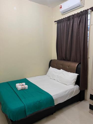 Dhiaa Homestay D Jembal في كوالا ترغكانو: سرير في غرفة عليها منشفتين