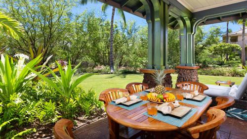 a wooden table and chairs on a porch at HAWAIIANA ESCAPE Tropical 3BR Kulalani Home with Bikes and Beach Club in Waikoloa