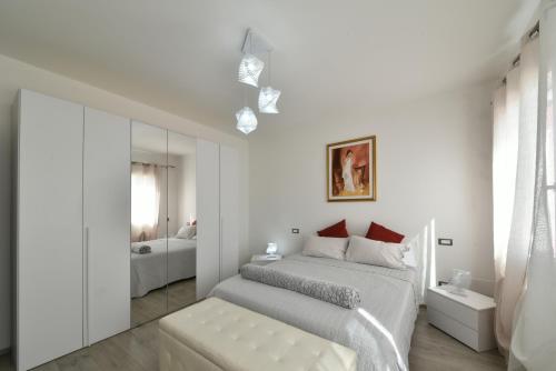 Habitación blanca con cama y espejo en I giardini di Lo', en Montagnana