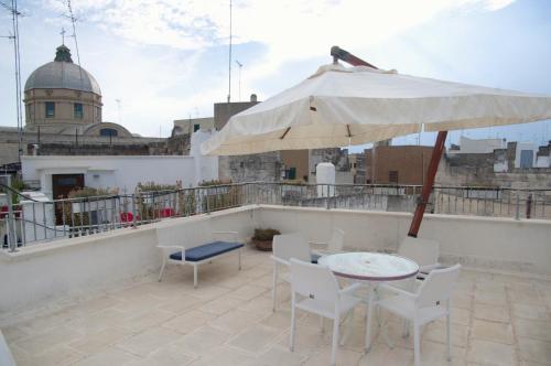 a patio with a table and an umbrella on a roof at B & B Sotto la Volta in Massafra