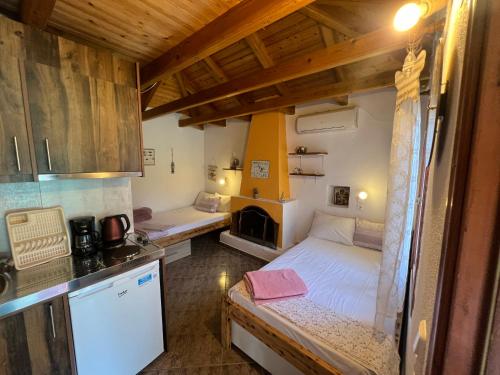 Habitación pequeña con cama y cocina en Aliki Stone House, en Alyki