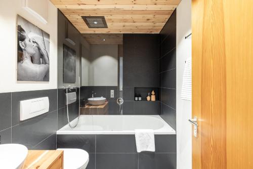 a bathroom with a bath tub and a sink at Chasa Serras Kuemin in Scuol