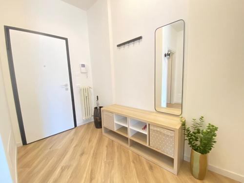 La salle de bains est pourvue d'un miroir et d'une commode avec une plante. dans l'établissement HOME BY NATY, à Brescia