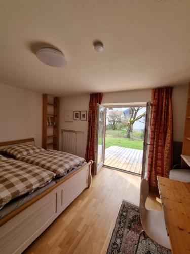 a bedroom with a bed and a sliding glass door at Großzügige Ferienwohnung mit Terrasse und Garten in Inzell