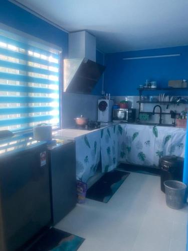 cocina con paredes azules y encimera en MyLittle Homestay en Tanjung Malim