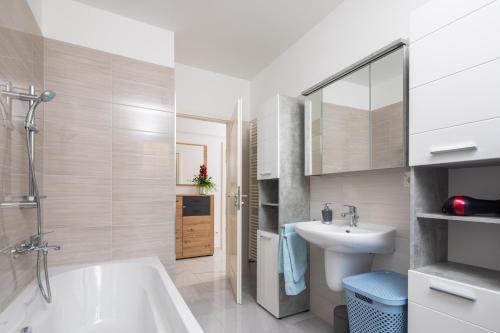 uma casa de banho com uma banheira branca e um lavatório. em Paramount Apartments em Dugi Rat