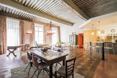 un salon avec une table et des chaises en bois dans l'établissement Le Voltaire - Hypercentre - 185 m2 - Très haut de gamme - 2 sdb -2 wc, à Grenoble