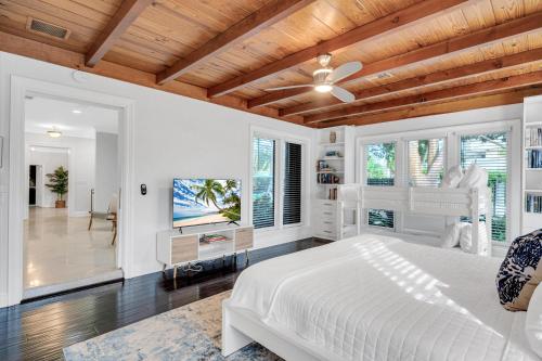 羅德岱堡的住宿－Private neighborhood Heated Pool Lush Surroundings Harbor Key RESlDENCES，卧室设有白色的床和木制天花板。