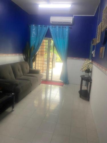 uma sala de estar com um sofá e uma janela em MyLittle Homestay em Tanjung Malim