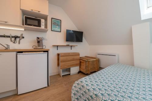 1 dormitorio con cama, fregadero y microondas en Gwenn Ha Du, en Merlevenez