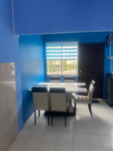 um quarto azul com uma mesa e duas cadeiras em MyLittle Homestay em Tanjung Malim