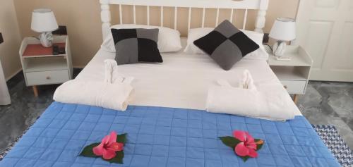a bedroom with a large bed with two flowers on it at Dan Kazou Self Catering in La Digue