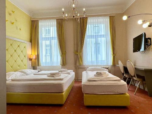 a bedroom with two beds and a desk and a table at Very Central, 5 min to city center, Self Check In in Vienna