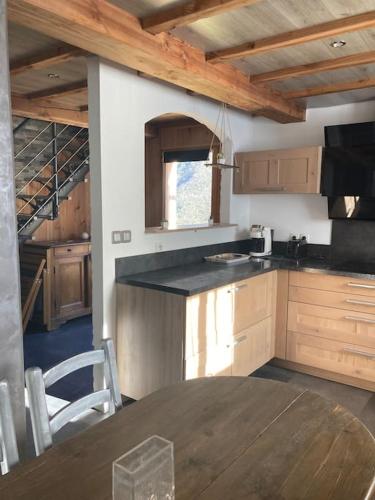 une cuisine avec une table en bois et une tableastery ... dans l'établissement L’Happyness maison à Figaret, à Utelle