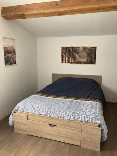 - une chambre avec un lit doté d'un cadre en bois dans l'établissement L’Happyness maison à Figaret, à Utelle