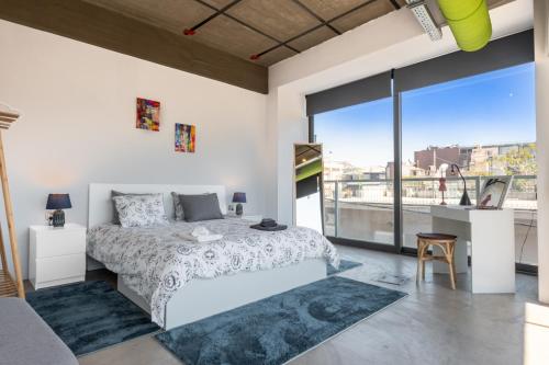 a bedroom with a bed and a large window at Ceramus Apartments Gazi View in Athens