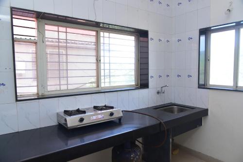 a kitchen with a stove and a sink at Mauli Villa, 4BHK Villa in Mahabaleshwar at Venna Lake in Mahabaleshwar