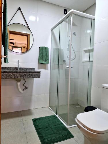 ein Bad mit einer Dusche, einem WC und einem Spiegel in der Unterkunft Pousada Makani Kai in Florianópolis