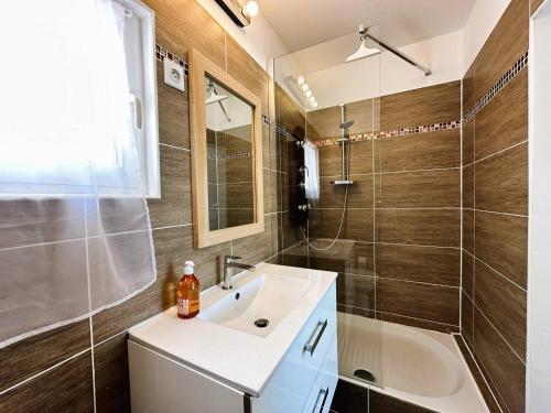 La salle de bains est pourvue d'un lavabo et d'une douche. dans l'établissement Villa CORAIL privée et climatisée pour 10 personnes avec piscine et superbe vue mer et collines à La Londe-les-Maures, à La Londe-les-Maures