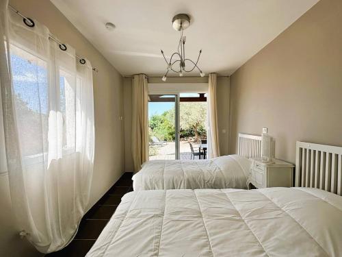 - une chambre avec 2 lits et une fenêtre dans l'établissement Villa CORAIL privée et climatisée pour 10 personnes avec piscine et superbe vue mer et collines à La Londe-les-Maures, à La Londe-les-Maures