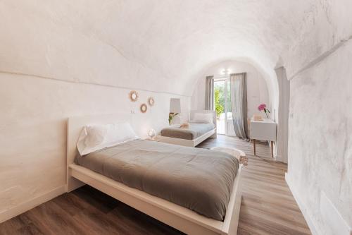 um quarto branco com uma cama e uma secretária em HelloApulia Trulli il Rifugio dei Messapi em Ceglie Messapica