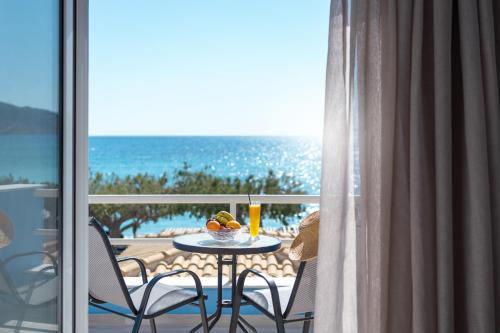 a table with a bowl of fruit on a balcony with the ocean at BOGGI in Goúdhouros