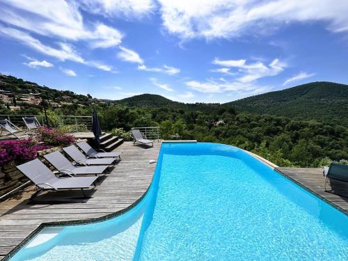 - une piscine avec des chaises et une vue sur les montagnes dans l'établissement Villa CORAIL privée et climatisée pour 10 personnes avec piscine et superbe vue mer et collines à La Londe-les-Maures, à La Londe-les-Maures