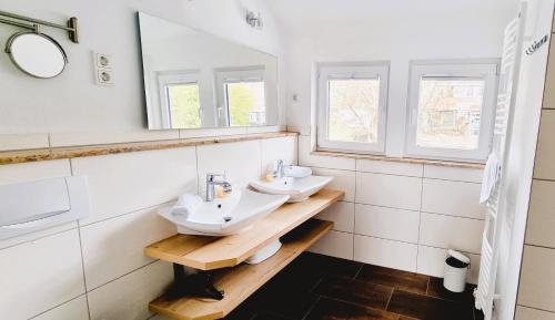 two sinks in a bathroom with two windows at Haus Siggi in Braunlage
