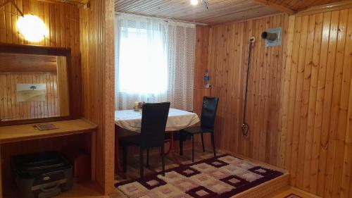 Habitación con mesa, sillas y ventana en Wooden room in garden house, en Najicheván