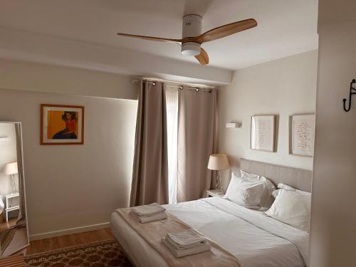 a bedroom with a bed with a ceiling fan at Cascais Twin Apartments - Daydream PT in Cascais